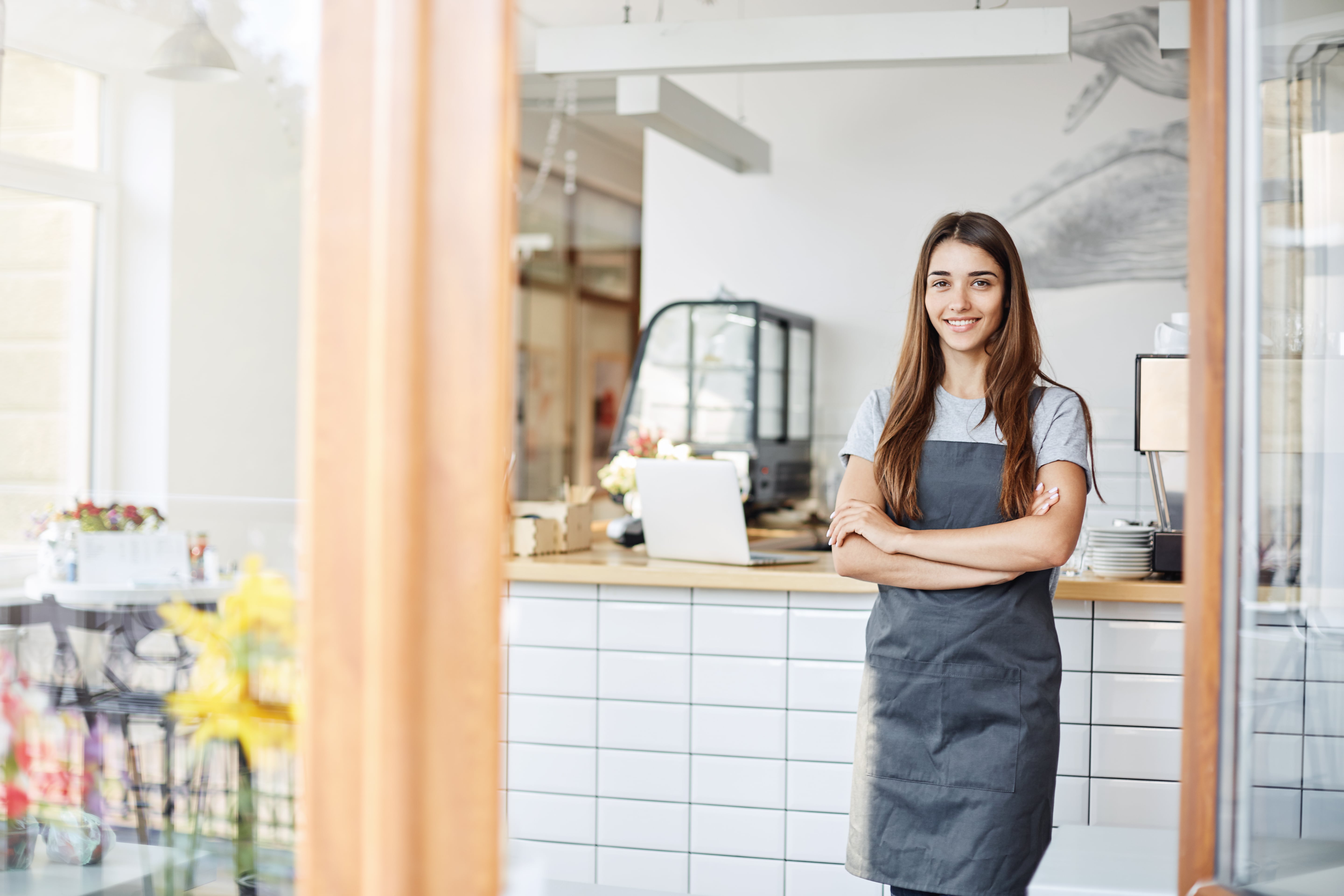 young-lady-entrepreneur-running-successful-small-cafe-standing-in-front-of-coffee-machine-with-arms-crossed-min.jpg